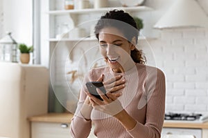 Shocked young latin woman reading incredible news on phone screen