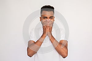 Shocked young man covering his mouth with hands