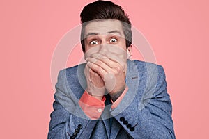 Shocked young man covering mouth