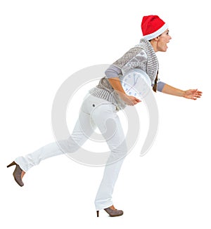 Shocked young woman and christmas hat running with clock