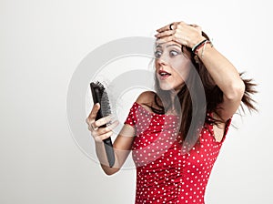 Shocked young woman with hair brush