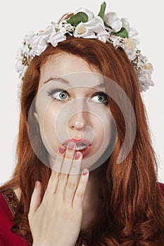 Shocked young woman in old-fashioned princess costume looking away against gray background