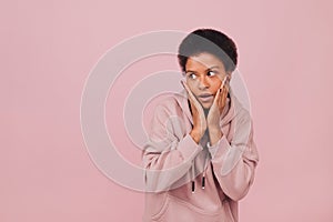 Shocked young woman posing over pink backdrop. Portrait with copy space