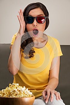 Shocked young woman watching 3D movie