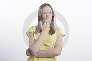 Shocking news. Surprised and calm woman covers her mouth, close-up, isolated on a white background