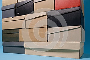 Shoe boxes stacked in a pile, on a blue background. Copy space. Shopping concept.