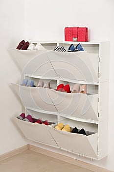 Shoe cabinet with footwear in room.