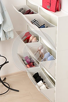 Shoe cabinet with footwear in room. Storage