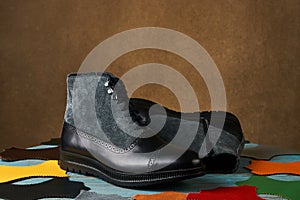 Shoe making concept with mens boots over brown background