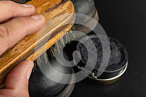 Shoe polish, brush and black military boots. Polishing and cleaning shoes on a black table