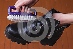 Shoe Polishing with female legs in black boots