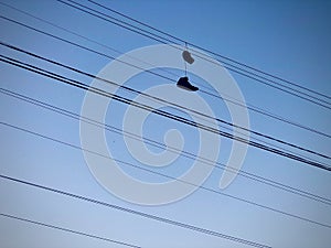 Shoe Tossing. Laced Pair of Shoes Tossed on the Power Line.