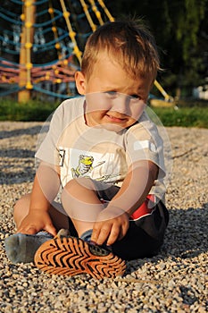 Shoeless child sitting on playground