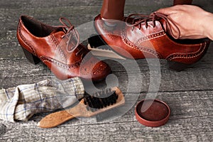 Shoemaker applying shoe shiner on shoe photo