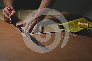 Shoemaker cutting leather with precision and steel ruler photo