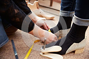 Shoemaker measuring customers feet, close up