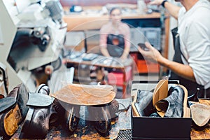 Shoemaker putting glue on sole of a shoe