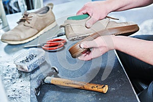 Shoemaker repair shoe. Glueing the sole for male footwear