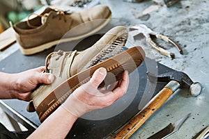 Shoemaker repair shoe. Glueing the sole for male footwear