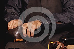 Shoemaker's workshop. A seated shoemaker sews shoes.