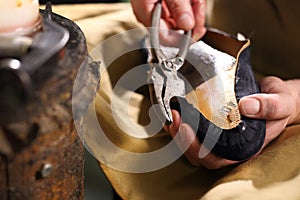 Shoemaker sews shoes