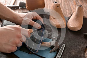 Shoemaker working with leather at factory