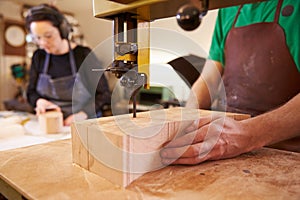 Shoemakers cutting and shaping wood to make shoe lasts