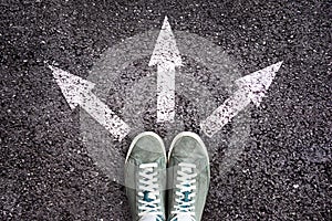 Shoes and arrows pointing in different directions on floor