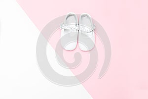 Shoes for babe on a white and pink background. Copy space