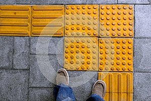 Shoes on block tactile paving for blind handicap photo