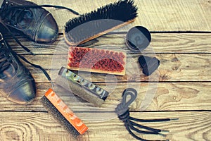 Shoes and care products for footwear on wooden background.
