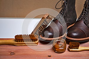 Shoes Cleaning Accessories for Dark Brown Grain Brogue Derby Boots Made of Calf Leather Over Paper Background with Cleaning Tools