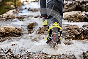 Shoes with crampons on a mountain trail in winter.