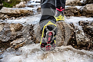 Shoes with crampons on the mountain trail in winter, climbing, adventure.