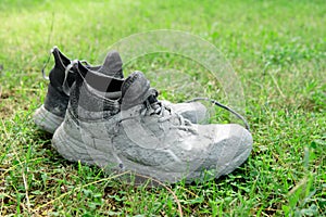 Shoes heavily stained in grey paint on the green grass