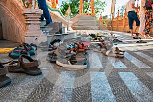 Shoes left at the entrance to the Buddhist temple. Concept of observing traditions, tolerance, gratitude and respect.