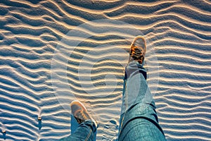 The shoes of a man standing on a sand dune photo