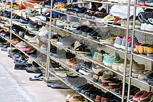 Shoes are organized in an orderly manner on shelves inside a temple