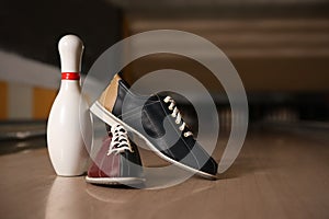 Shoes and pin on bowling lane in club