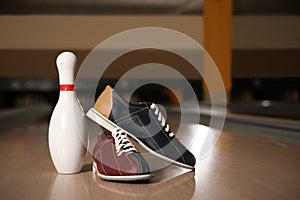 Shoes and pin on bowling lane in club