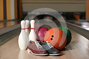 Shoes, pins and balls on bowling lane in club