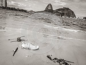 Shoes stranded washed up garbage pollution on beach Brazil