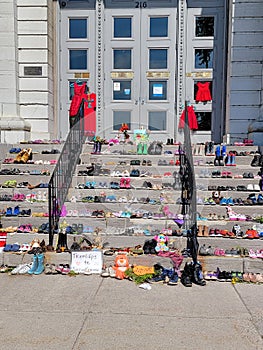Shoes and teddy bears left on kingston city hall steps in memory of 215 children's graves found in kamloops