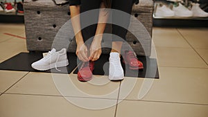 shoes. try on shoes. close-up. sneakers. shoe store. White running shoes. woman trying on new white sneakers in a shoe