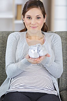 shoes unborn baby on hands pregnant woman