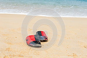 Shoes on white sand beach in day noon light