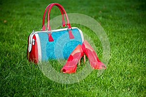 Shoes and women's handbag lay on the grass, women's shoes