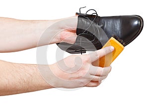 Shoeshiner cleaning black shoes by brush