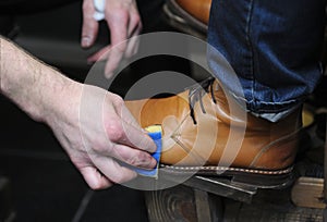 Shoeshiner polishing clientâ€™s boots