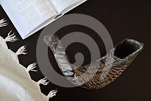 Shofa Tallit and Jewish prayer book on a wooden table